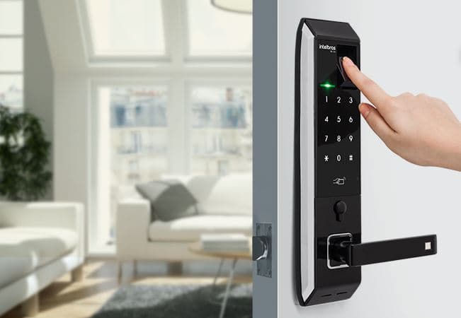 Pessoa utilizando leitor biométrico em fechadura digital Intelbras instalada em porta de entrada residencial.