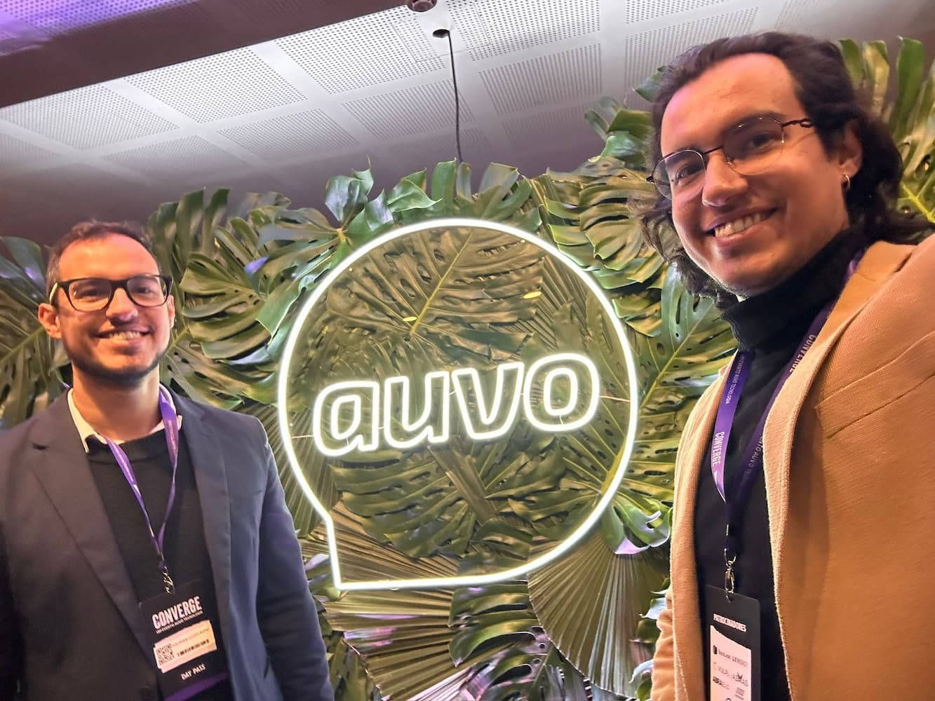 Leonardo e Guilherme da Prime Smart House em frente ao letreiro da Auvo no evento Converge 2025