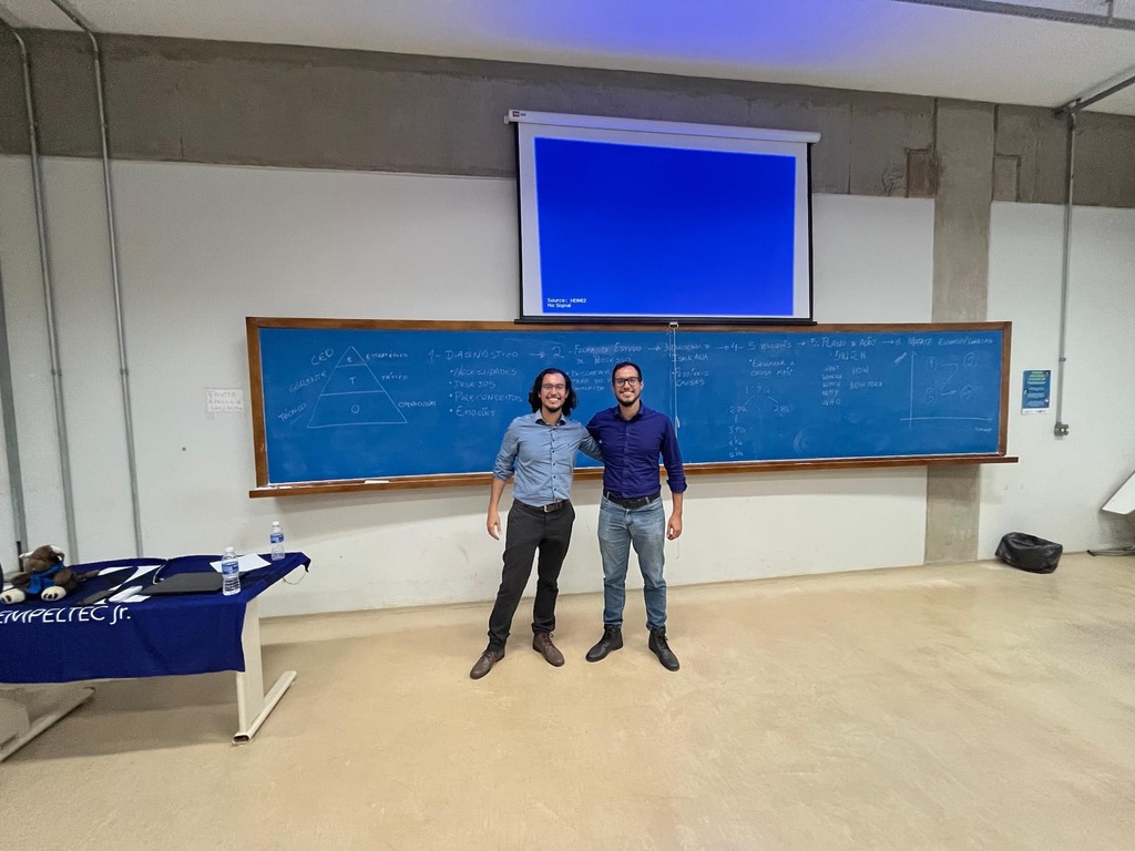 Leonardo e Guilherme da Prime Smart House posando em frente ao quadro após palestra para a Empeutec Jr. na UFSCar.